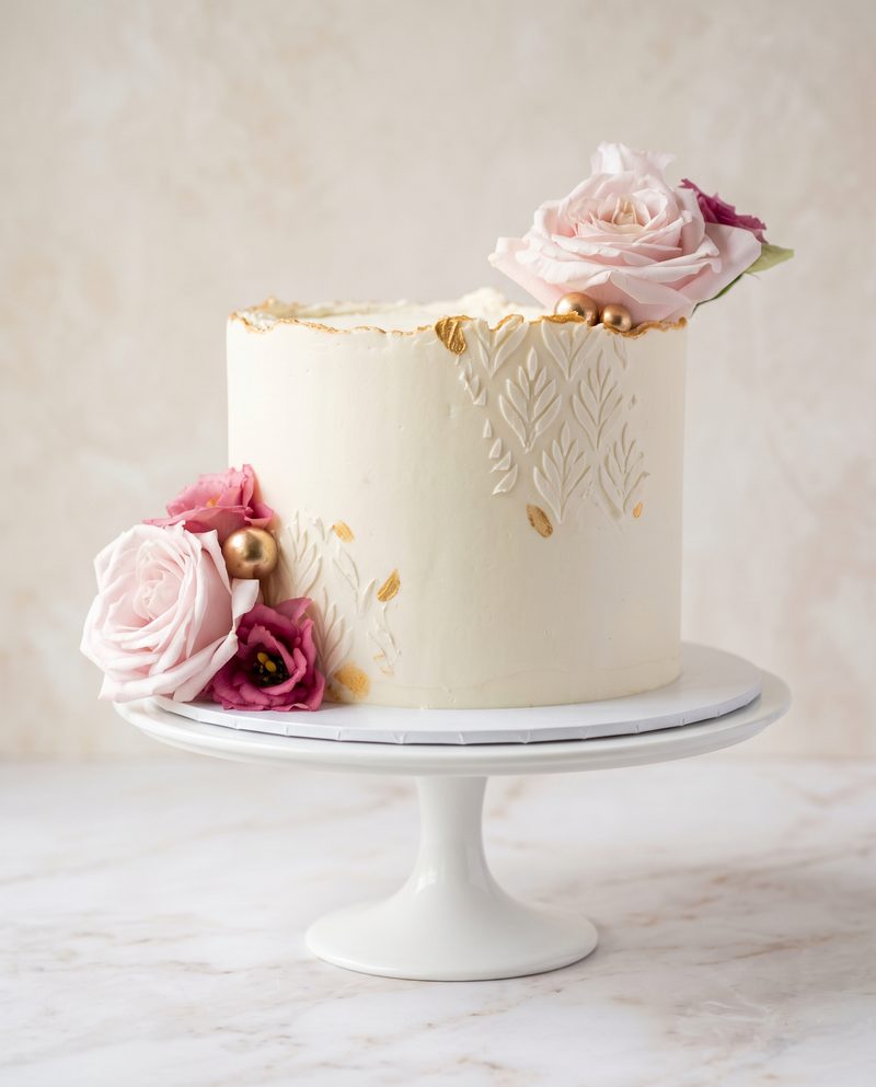 Gâteau d'anniversaire blanc, dentelle en relief et roses roses
